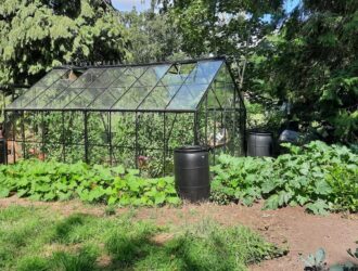 Une serre de jardin entourée par un environnement naturel riche